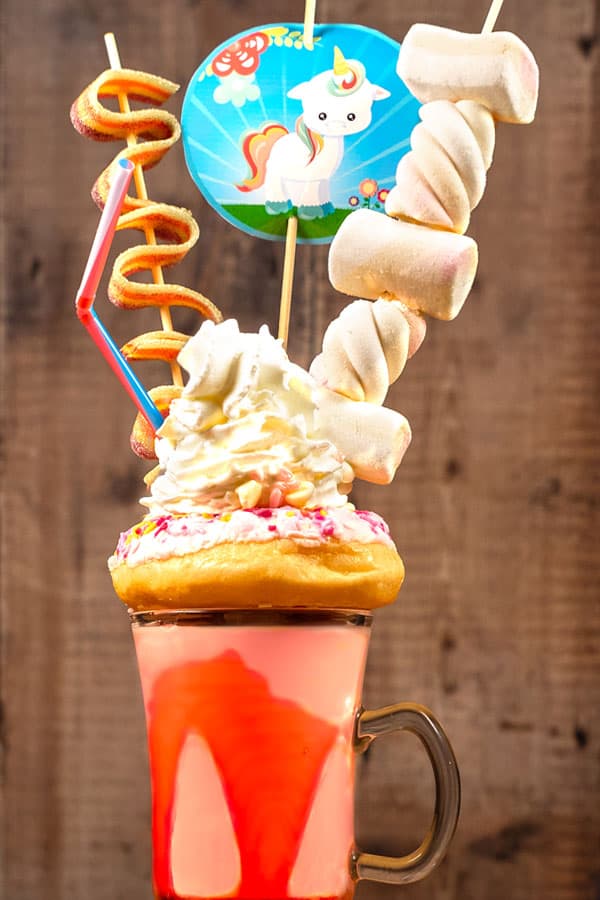 Strawberry unicorn freakshake with doughnuts and marshmallows